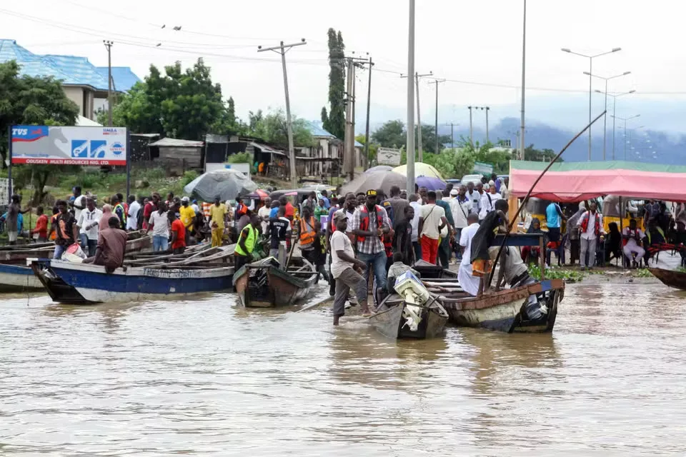 File Photo: People stranded due to floods following several days of downpours in Kogi, Nigeria. October 6, 2022. FATAI CAMPBELL / AP