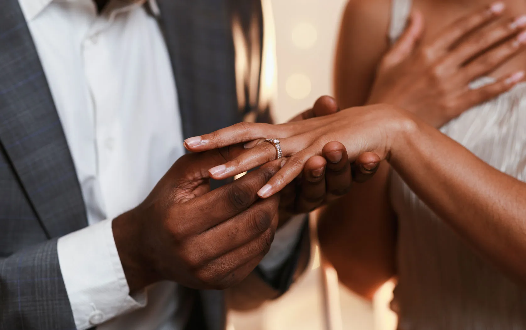 A man putting a ring on a woman's finger.